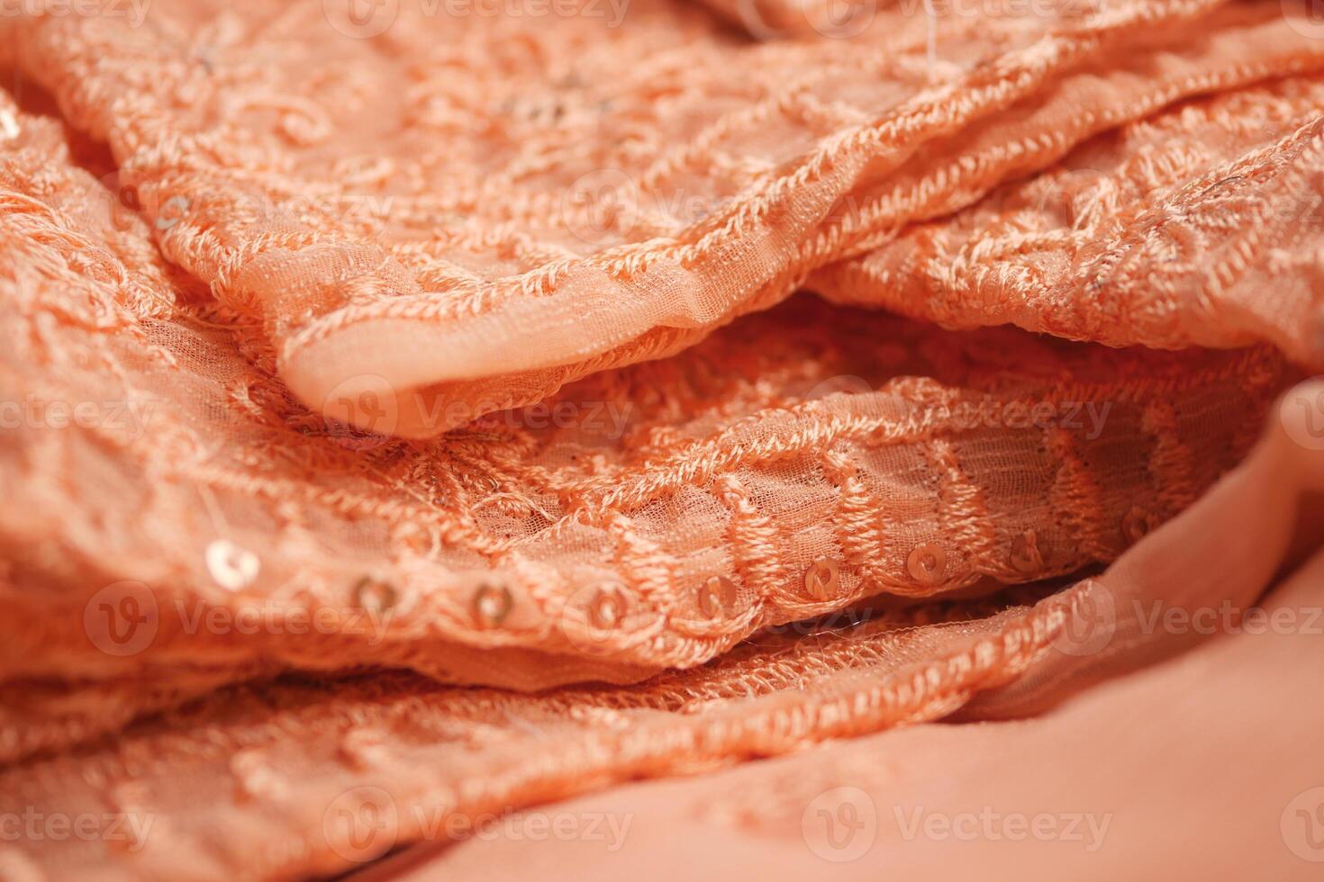 Elegant peach embroidered fabric showcasing intricate detailing photo
