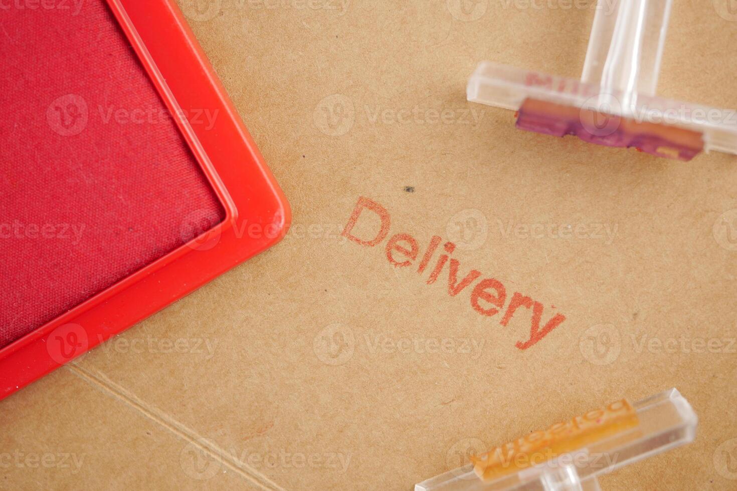 Delivery stamp and tools on brown paper background in workspace photo