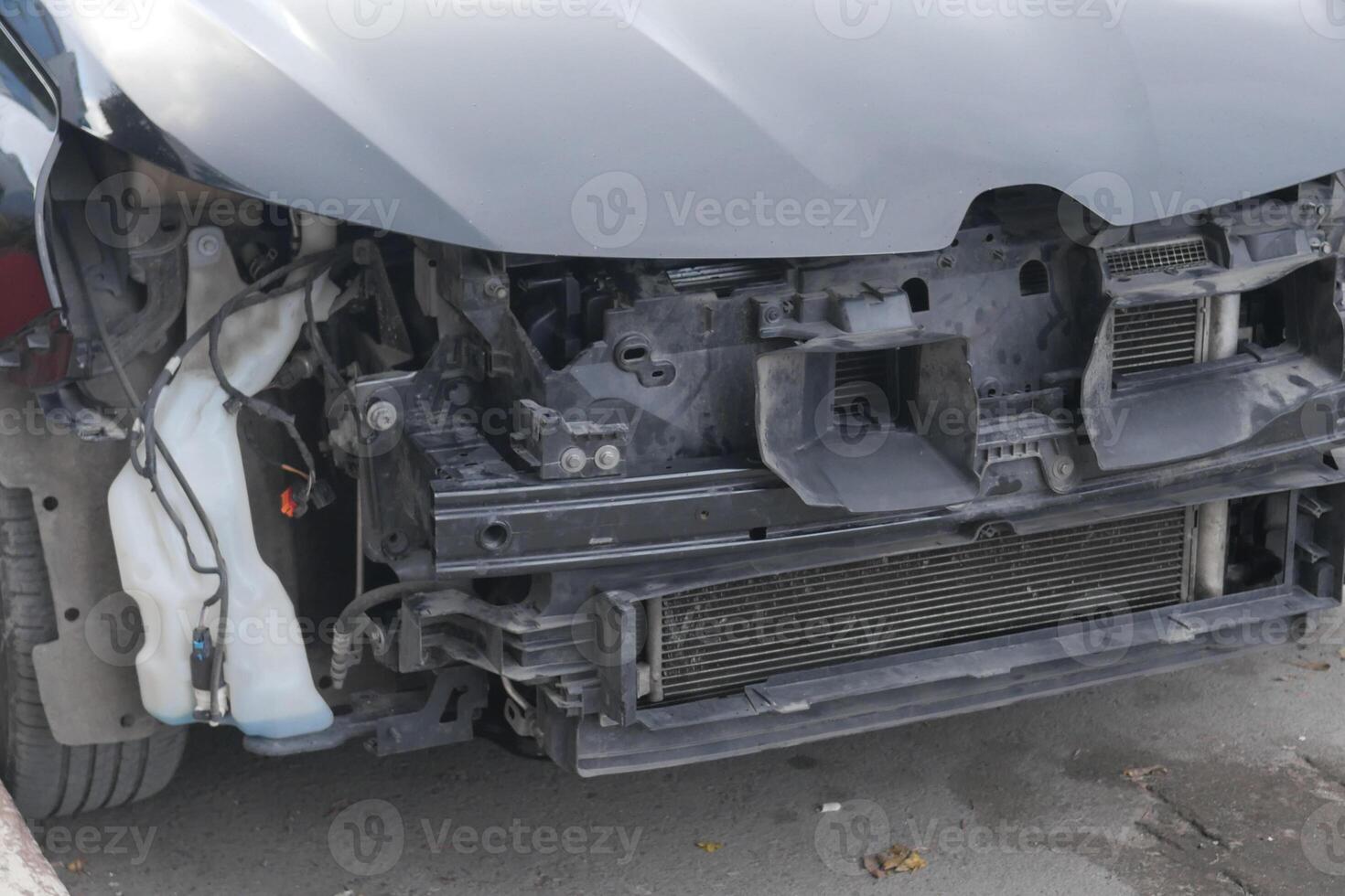 Car front end partially dismantled for repair outside in daylight photo