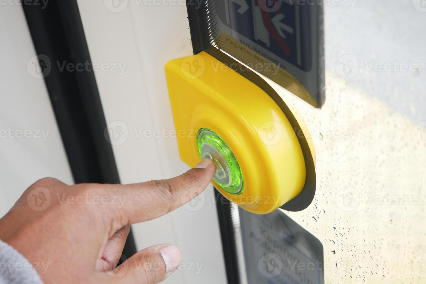 Hand pressing button to open door at modern transit station photo