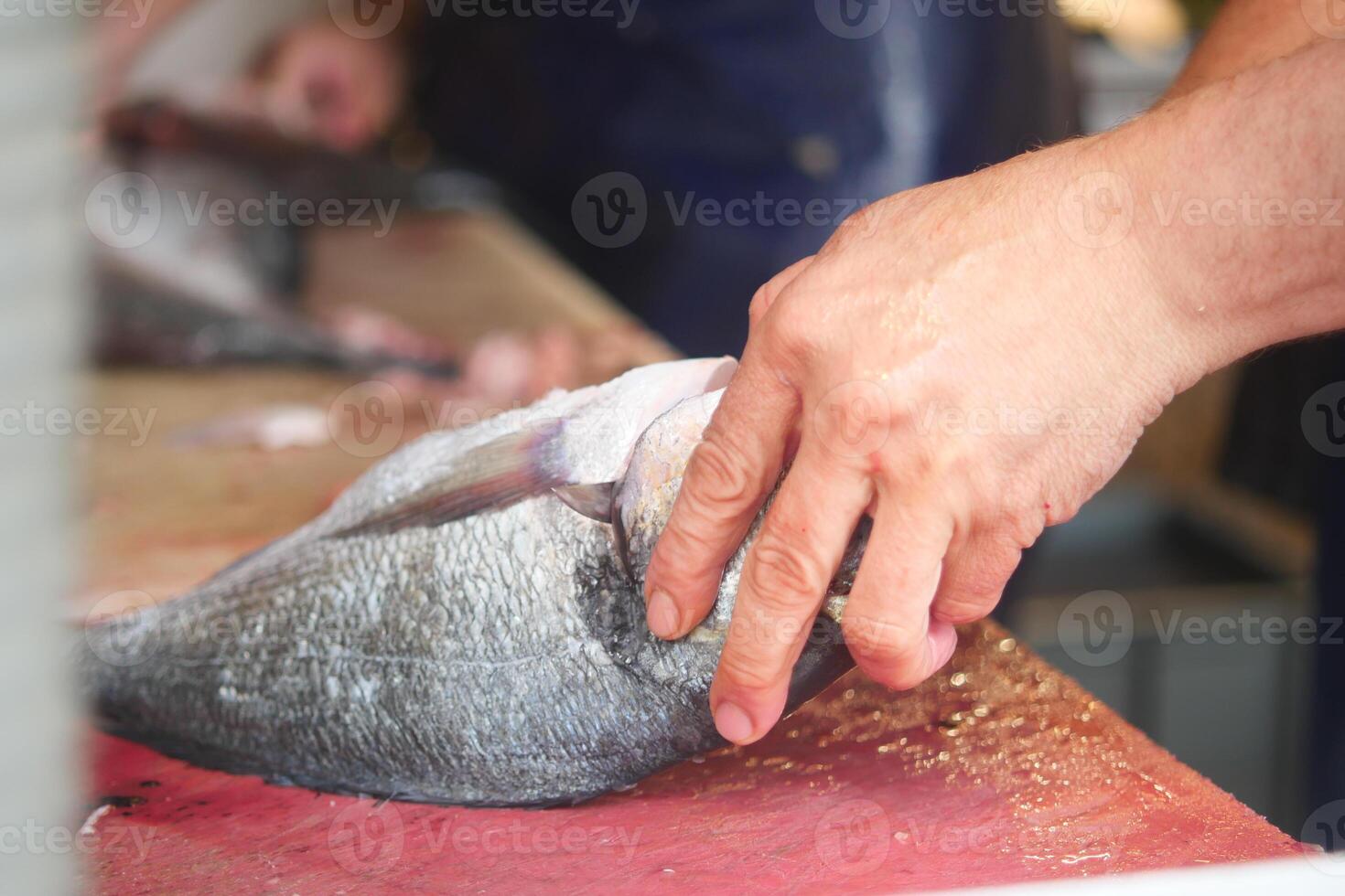 Market vendor prepares fresh fish at local seafood stall photo