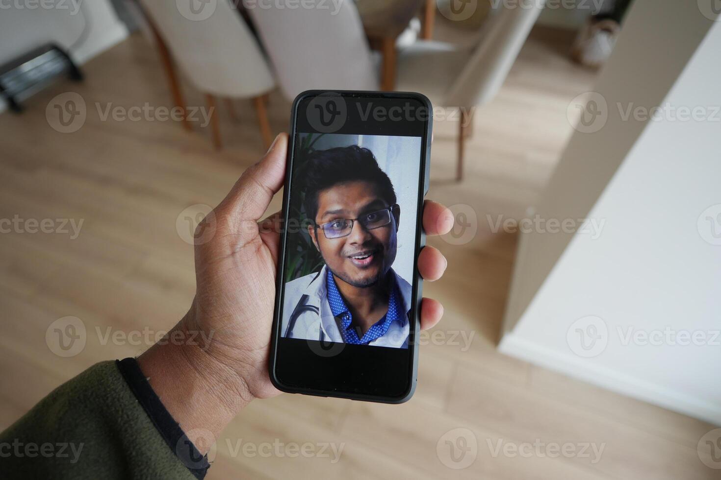 Person Holding Smartphone Displaying a doctor Smiling Face photo