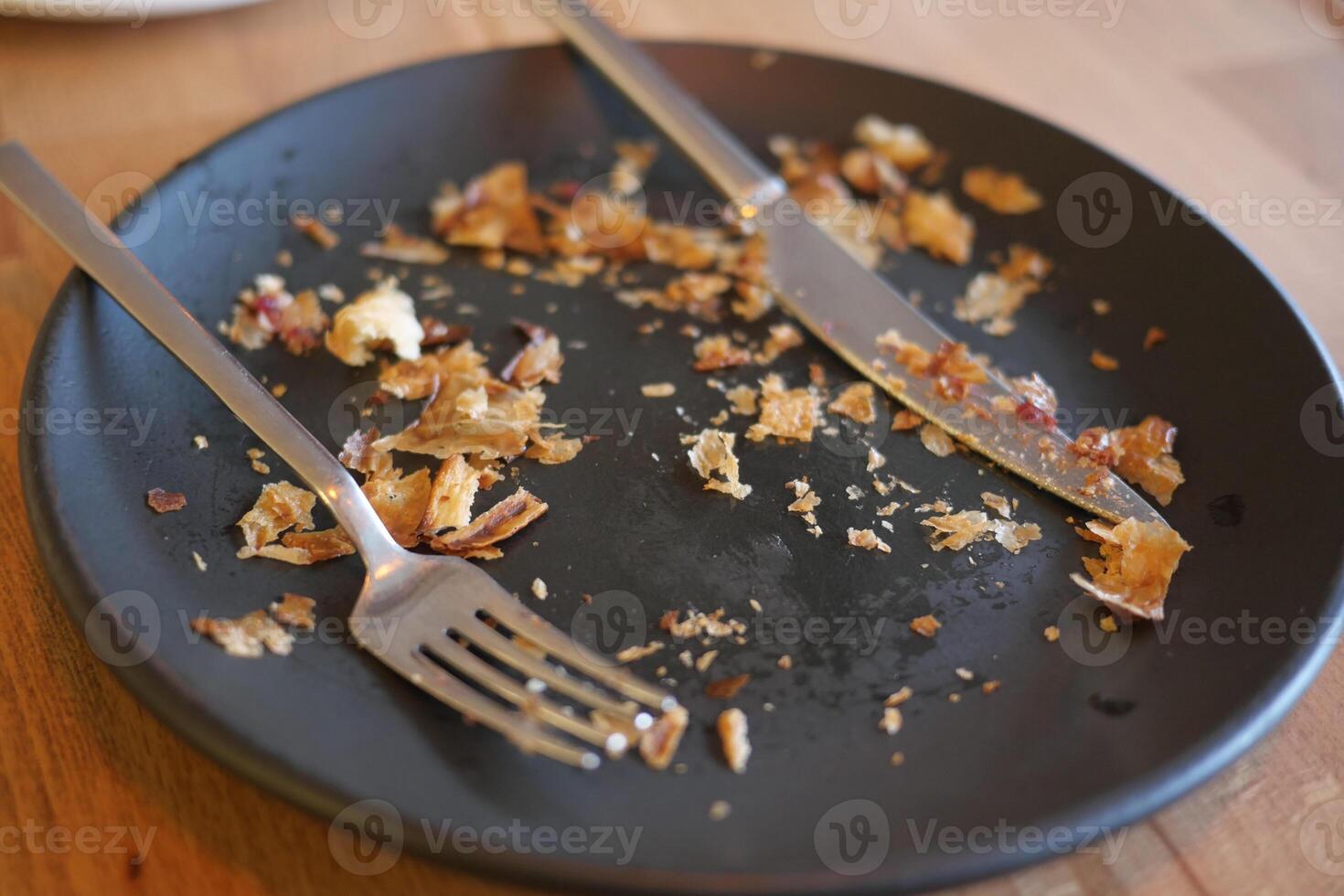 Leftover crumbs on a black plate after a delicious meal photo