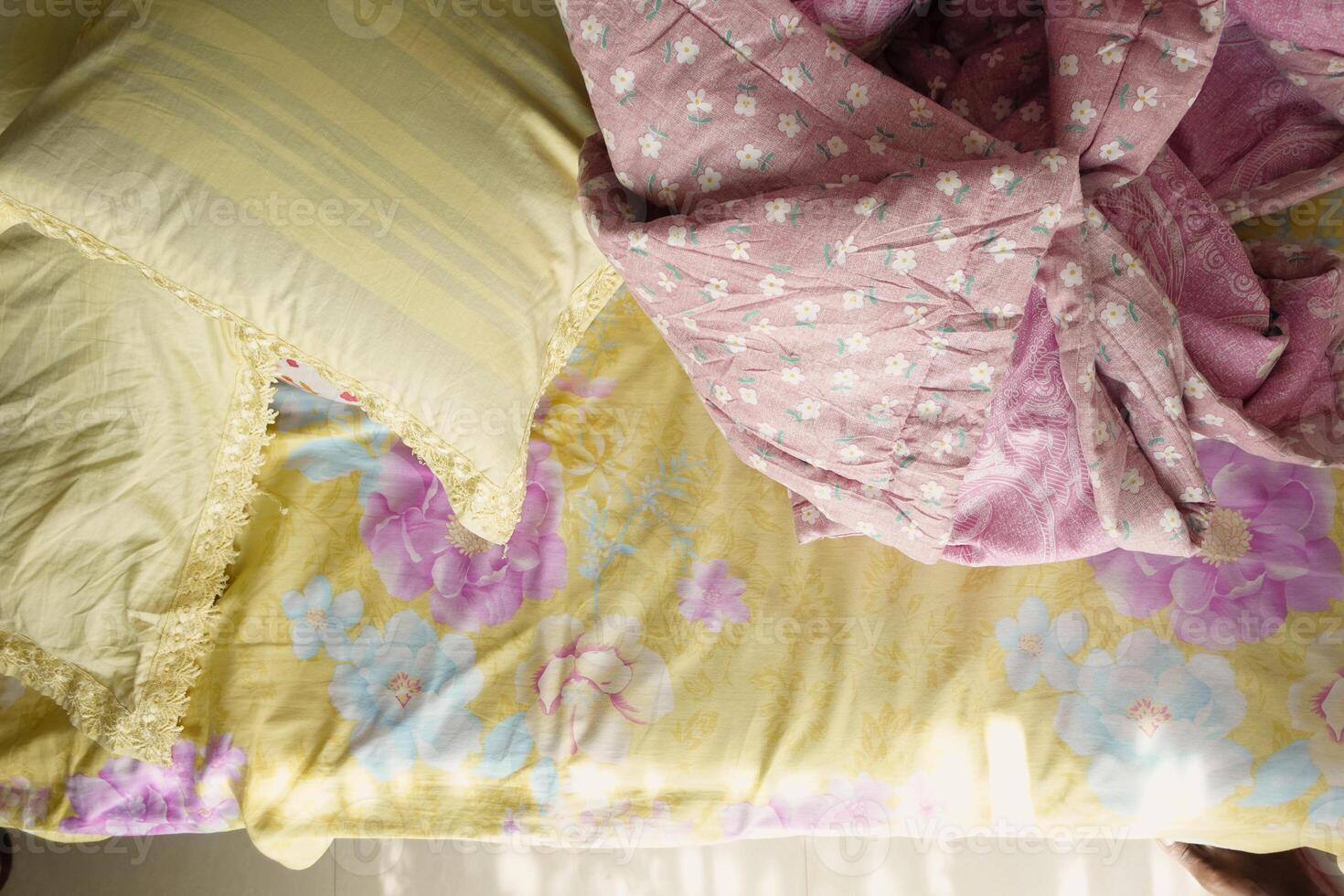 Cozy bed with colorful bedding and pillows in a bright room photo