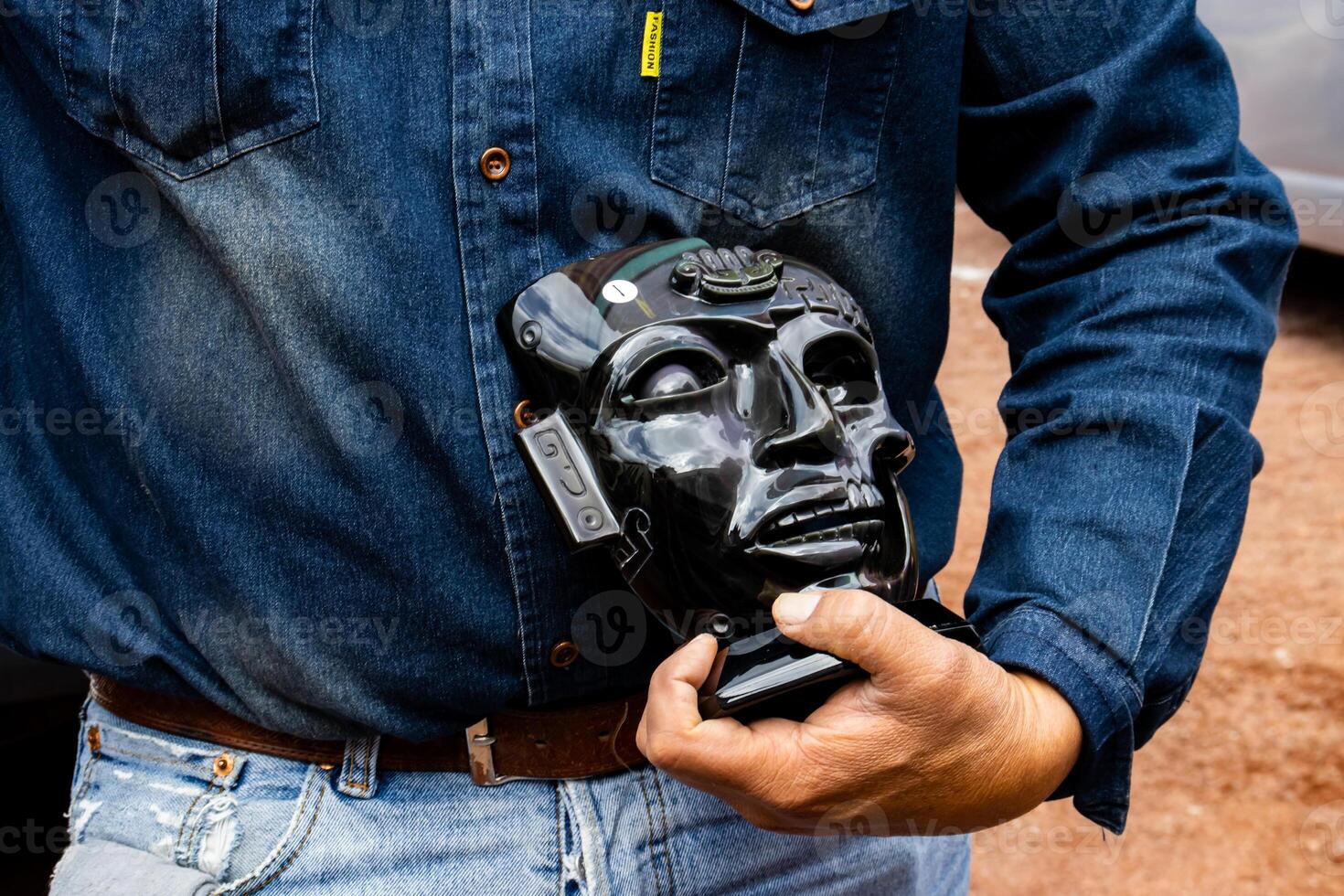 Guide showing an obsidian handcraft to a group of visitors at the Teotihuacan archeological site. photo