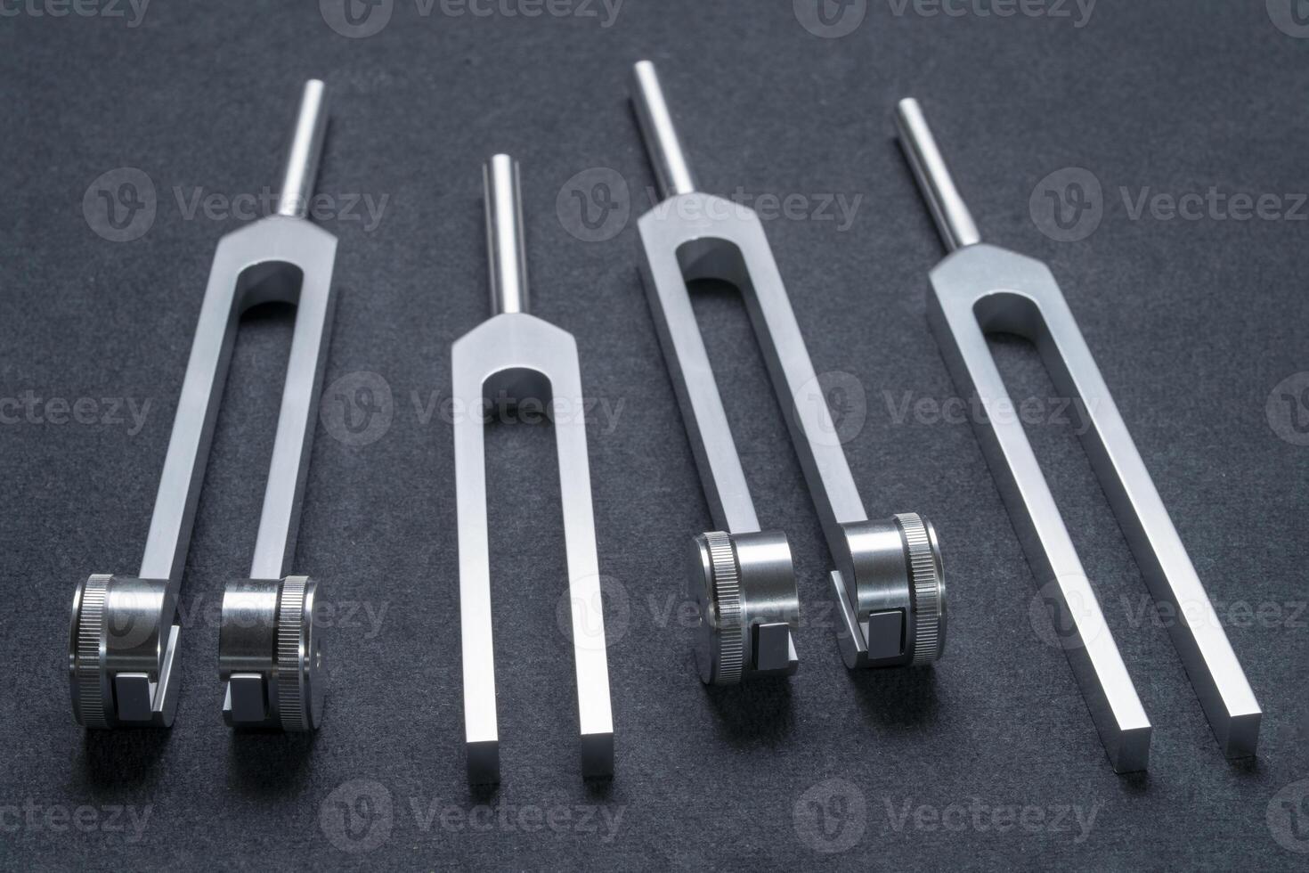 weighted and unweighted metal tuning forks used for tuning musical instruments, sound therapy or relaxation. photo