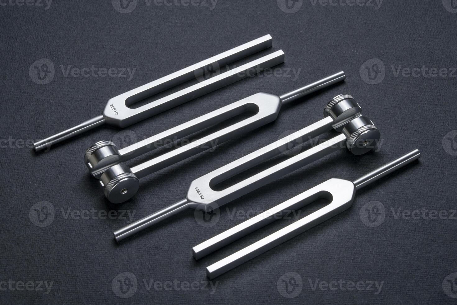 weighted and unweighted metal tuning forks used for tuning musical instruments, sound therapy, or relaxation. photo
