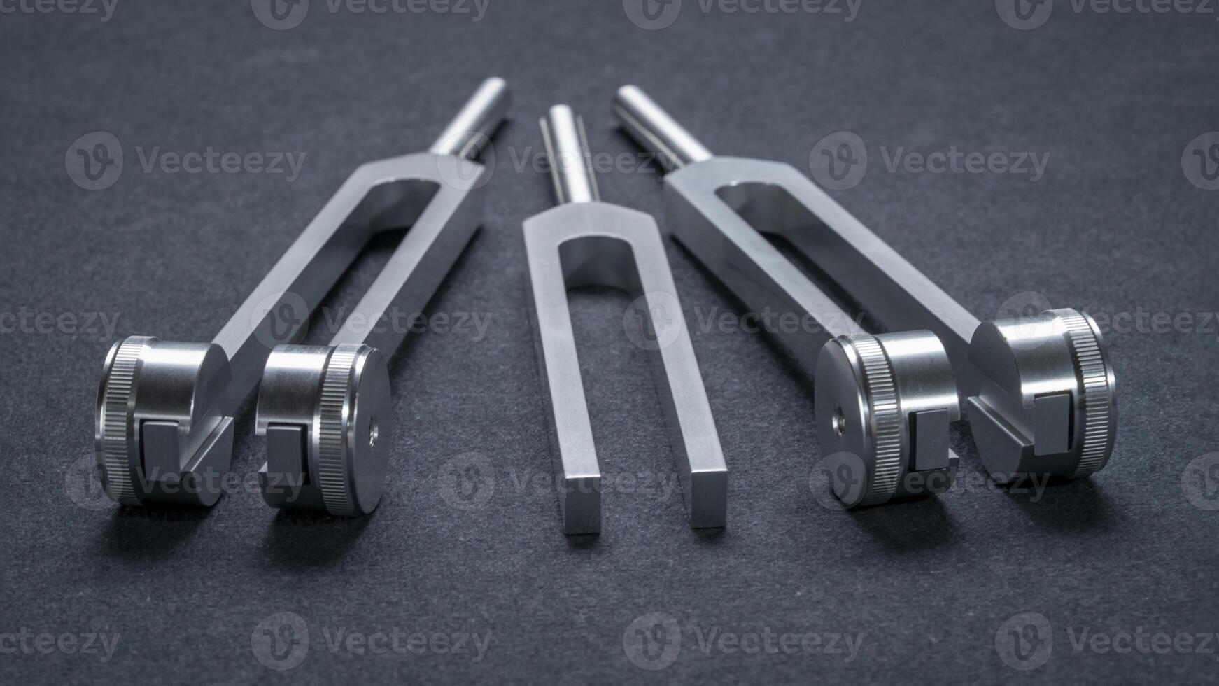 weighted and unweighted metal tuning forks used for tuning musical instruments and sound therapy, chakra healing photo