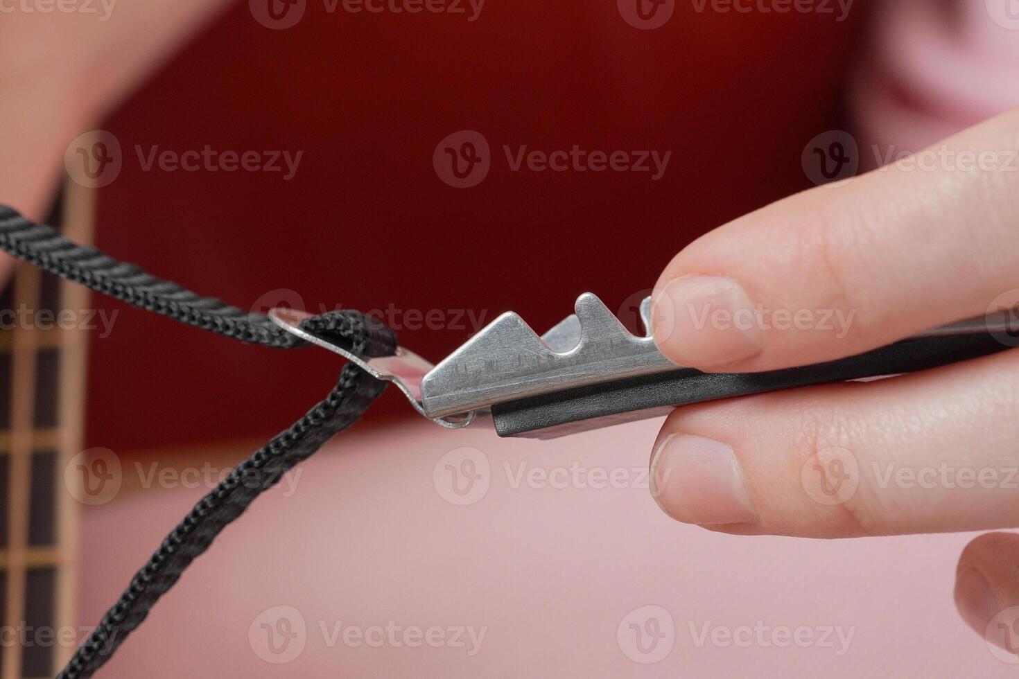 Extreme closeup view of woman's fingers as she holding capodastro photo