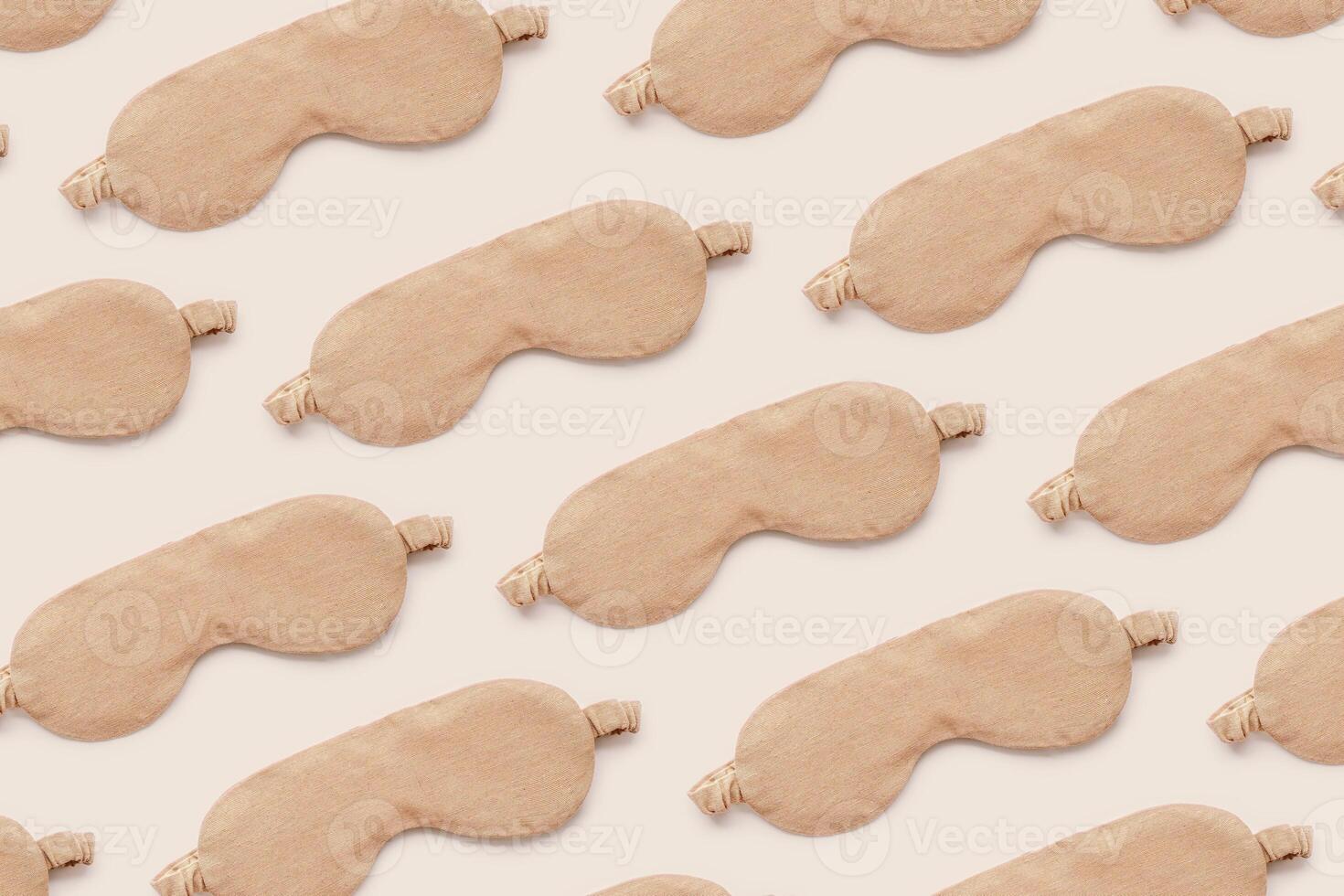 Trendy Minimal pattern from beige sleep masks on beige background, above view. Neutral colored stylish cloth eye masks for best sleeper, for travel, rest. Night time and sleep concept photo