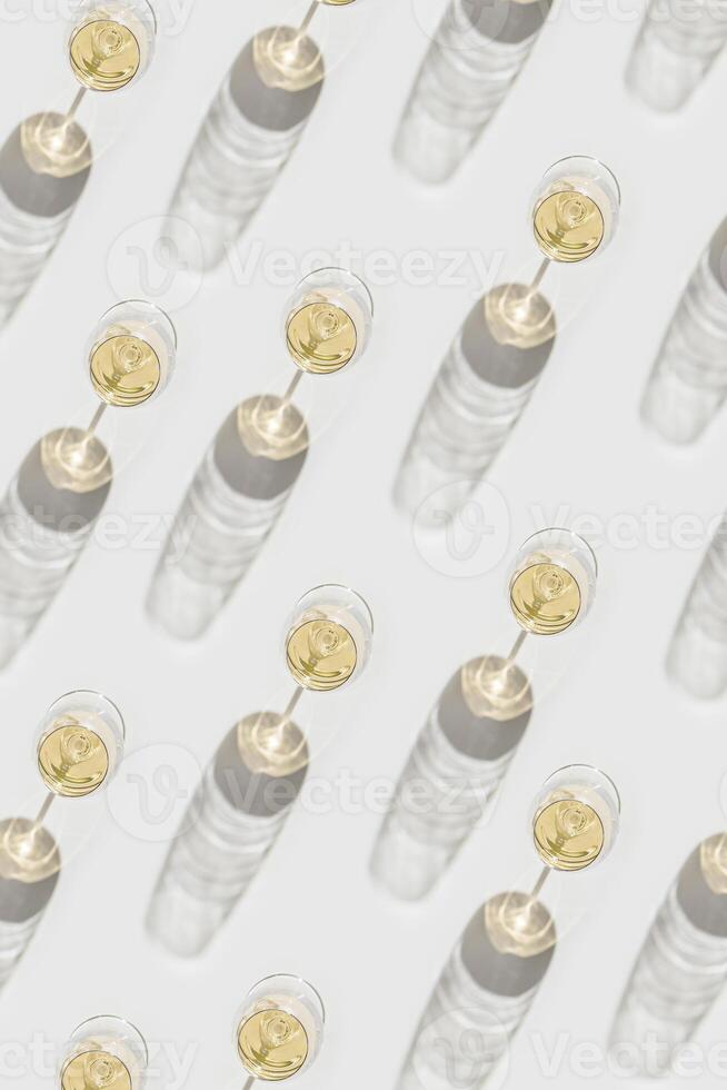 Creative pattern with Many glasses of white wine, Aesthetic top view pattern, minimal style flat lay. Wine glass at sunlight, sun shadows and shiny glare glass. Light alcohol drinks for party photo