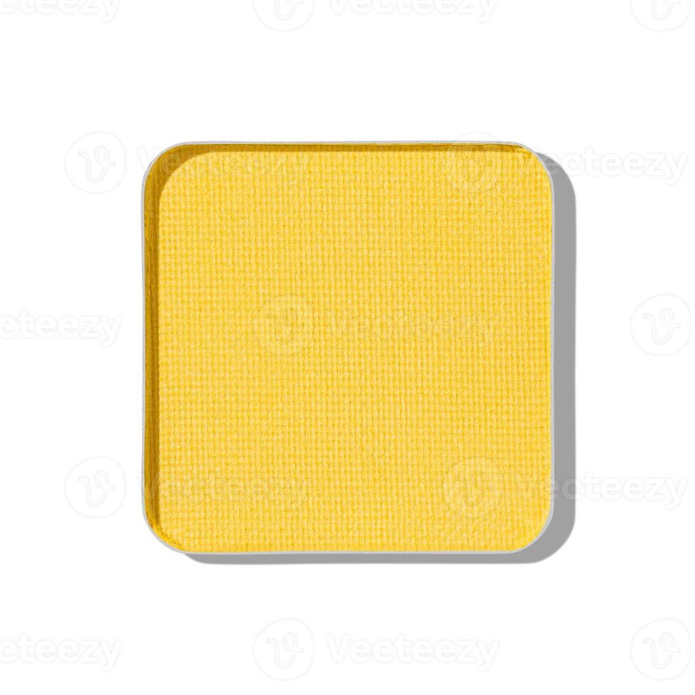 Top view eye shadow yellow swatch, object isolated on white background with shadow, sparkling eyeshadow, colored matte powder for festive makeup, square shape metal pack, beauty texture photo