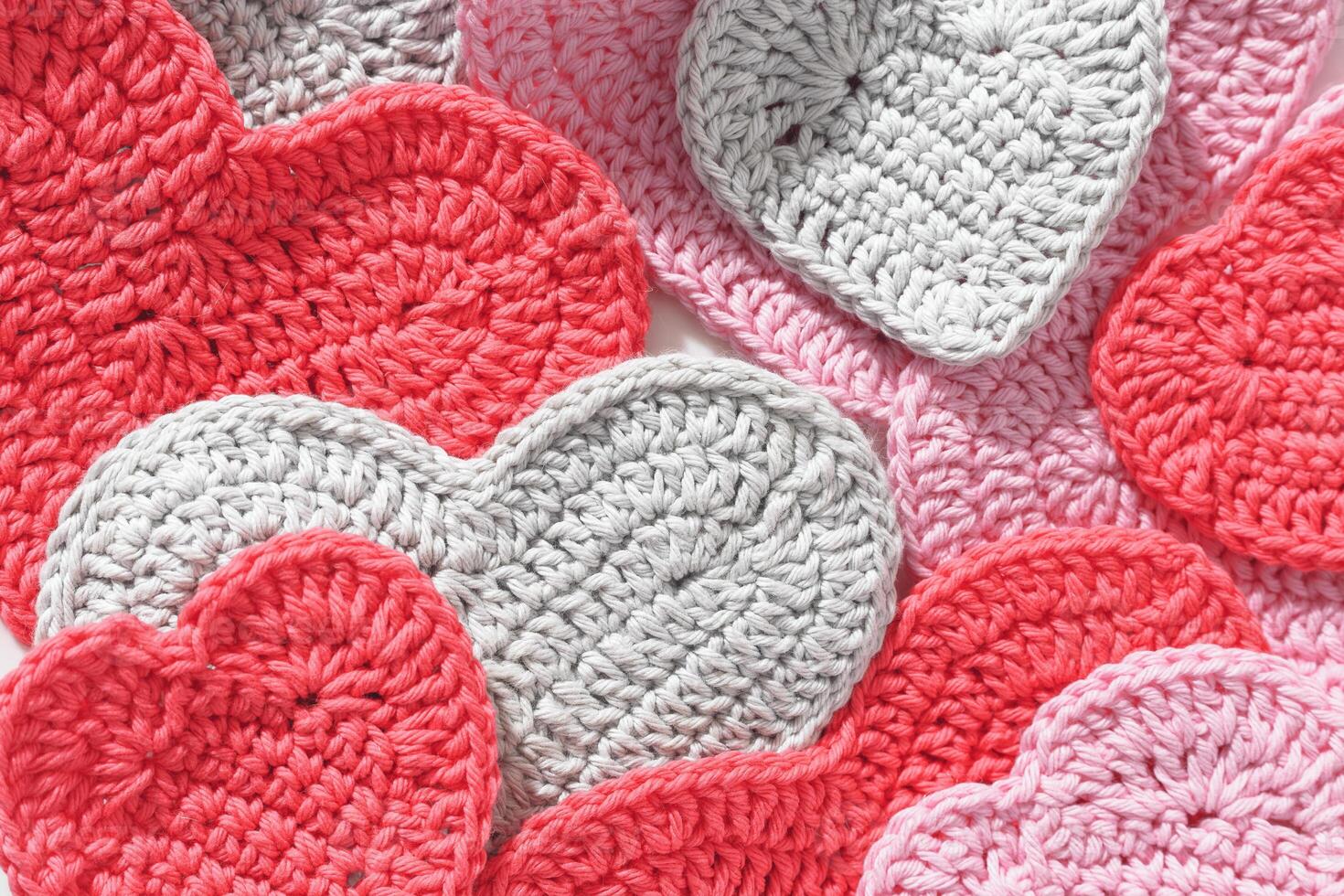 Pink red knitted valentine hearts as close up textured background. Minimal style flat lay photo, Valentine's Day, romantic relationship, love, wedding concept, top view texture, tender pastel photo