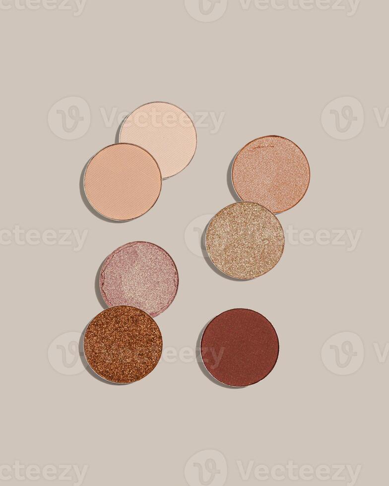 Pattern with eye shadow beige brown natural color on neutral colored background. Makeup palette, set of swatches eyeshadows powder, shine and matte, minimal style, pastel colored, flat lay photo