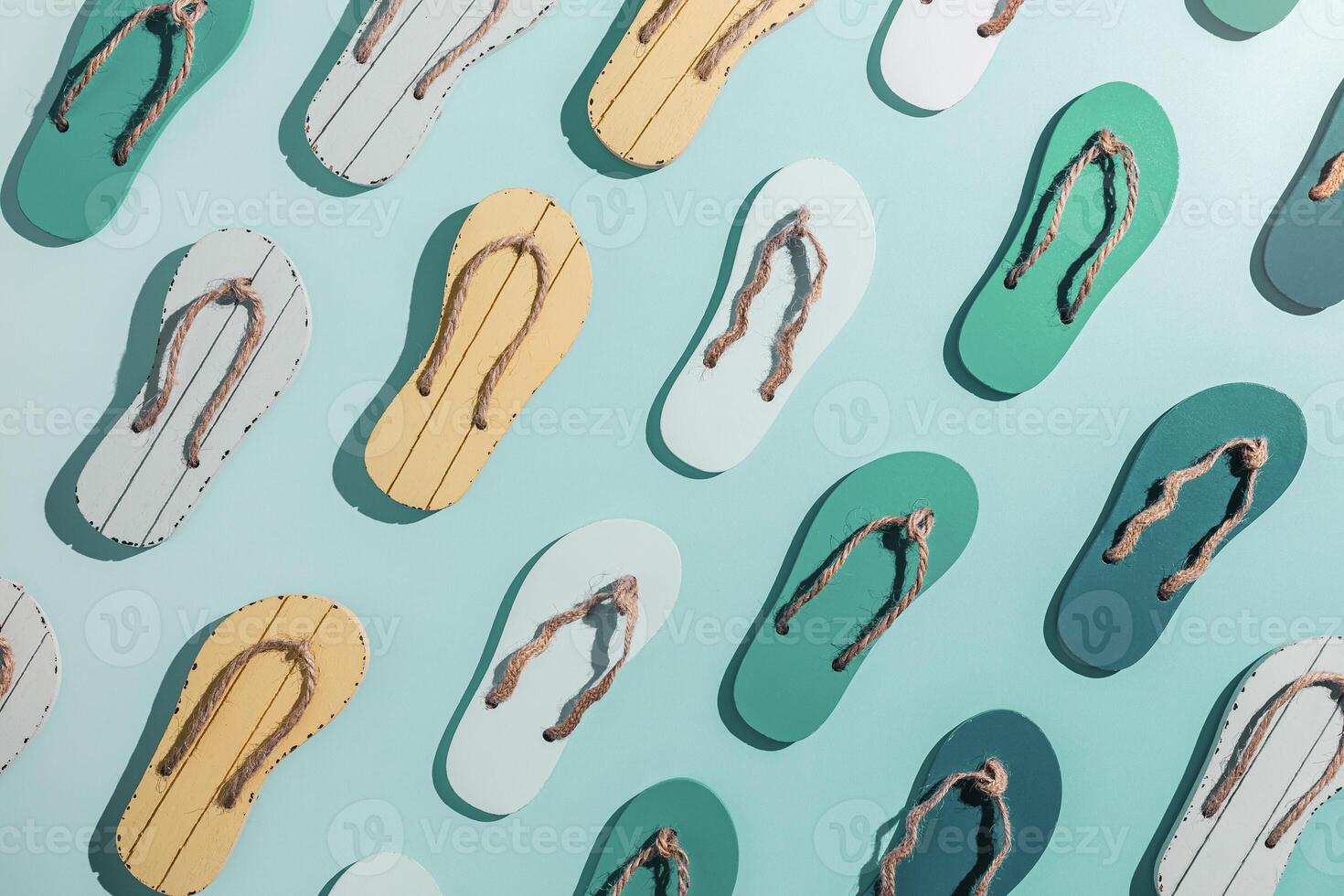 Female summer shoes sandals as creative minimal pattern with hard shadow, blue green yellow flip flops on turquoise gradient color background. Aesthetic trend summer fashion concept, life style photo