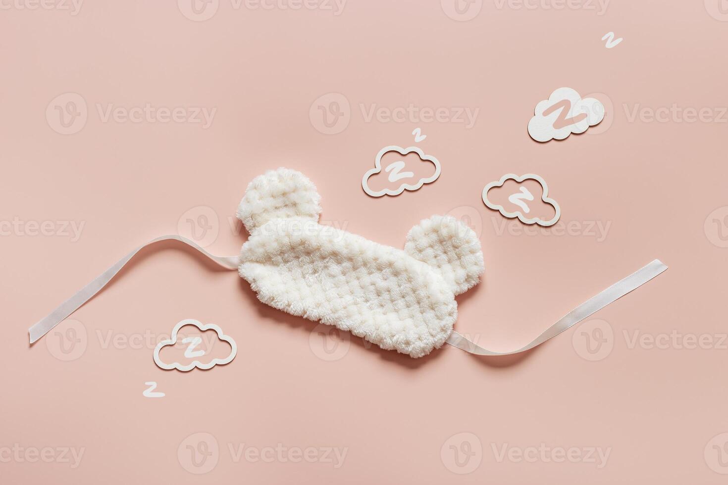 Sleep mask from soft nice fur and clouds shape with zz snore sounds on pink background. Light Fluffy eye cover mask for best sleep. Concept of travel comfort, dream well, rest at night, Minimal photo