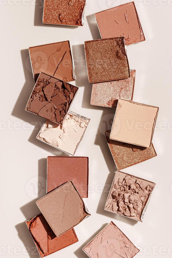 Beauty product neutral color eyeshadows for makeup, beige monochrome pattern on light background, flat lay with nude colors swatches eyeshade, cosmetic textures, beige color palette, top view pattern photo