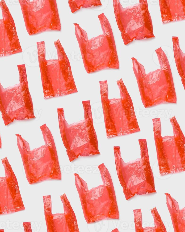 Top view pattern from Red plastic bags. Single-use polythene packet, Eco trend to reduce disposable plastics, Biodegradable packaging waste, creative photo pattern as design background