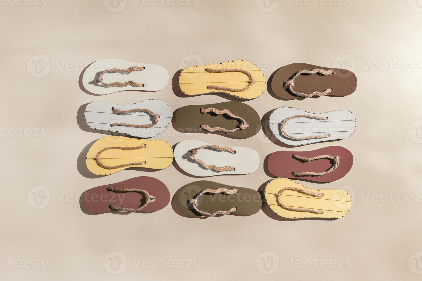 Summer flip flops flat lay, minimal square pattern, set of beach footwear neutral colored, top view still life with womans slide sandals, many shoes, summer beach holiday concept, shadow from sunlight photo