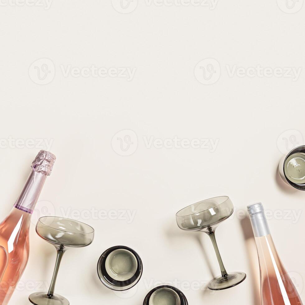 Summer drinks, rose wine and sparkling water, trendy glasses from tinted grey glass on beige background, copy space. Minimal style summer drink concept. Top view table, beautiful drinkware, flat photo