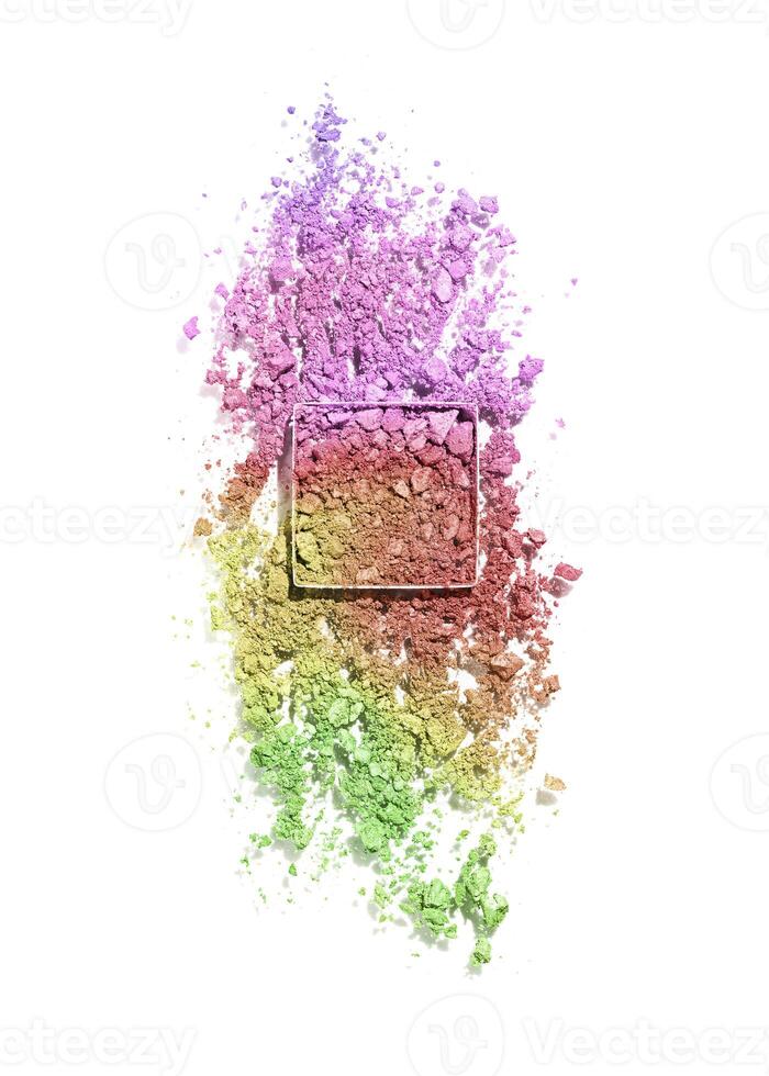 Crushed eye shadow powder cosmetics swatch isolated on white background, green yellow red color gradient. Bright make up powder texture. Broken eye shadow smear. Top view face cosmetic product sample photo