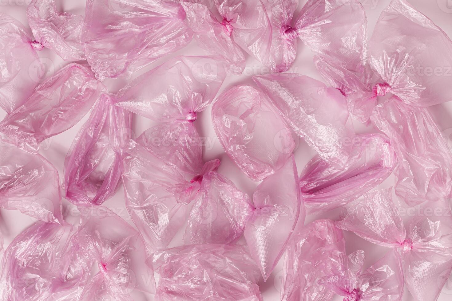 Plastic free environment protection concept. Empty used plastic bags as background Top view magenta disposable polyethylene packets, aesthetic monochrome texture background. Plastic bag free day photo