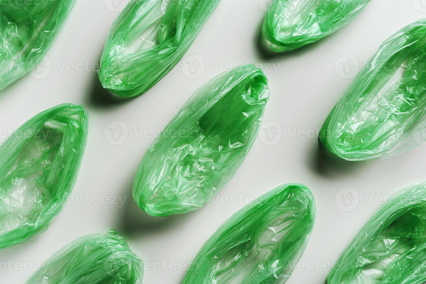 Minimal flat lay from green disposable plastic bags on white background. Waste reduction, Save planet, eco, recycling concept. Pollution from Polyethylene packets, not use plastic bag photo