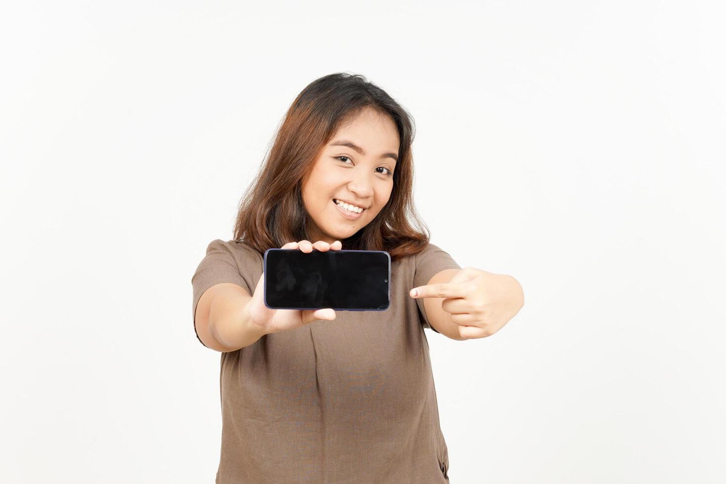 A woman holding up a cell phone and pointing at it photo