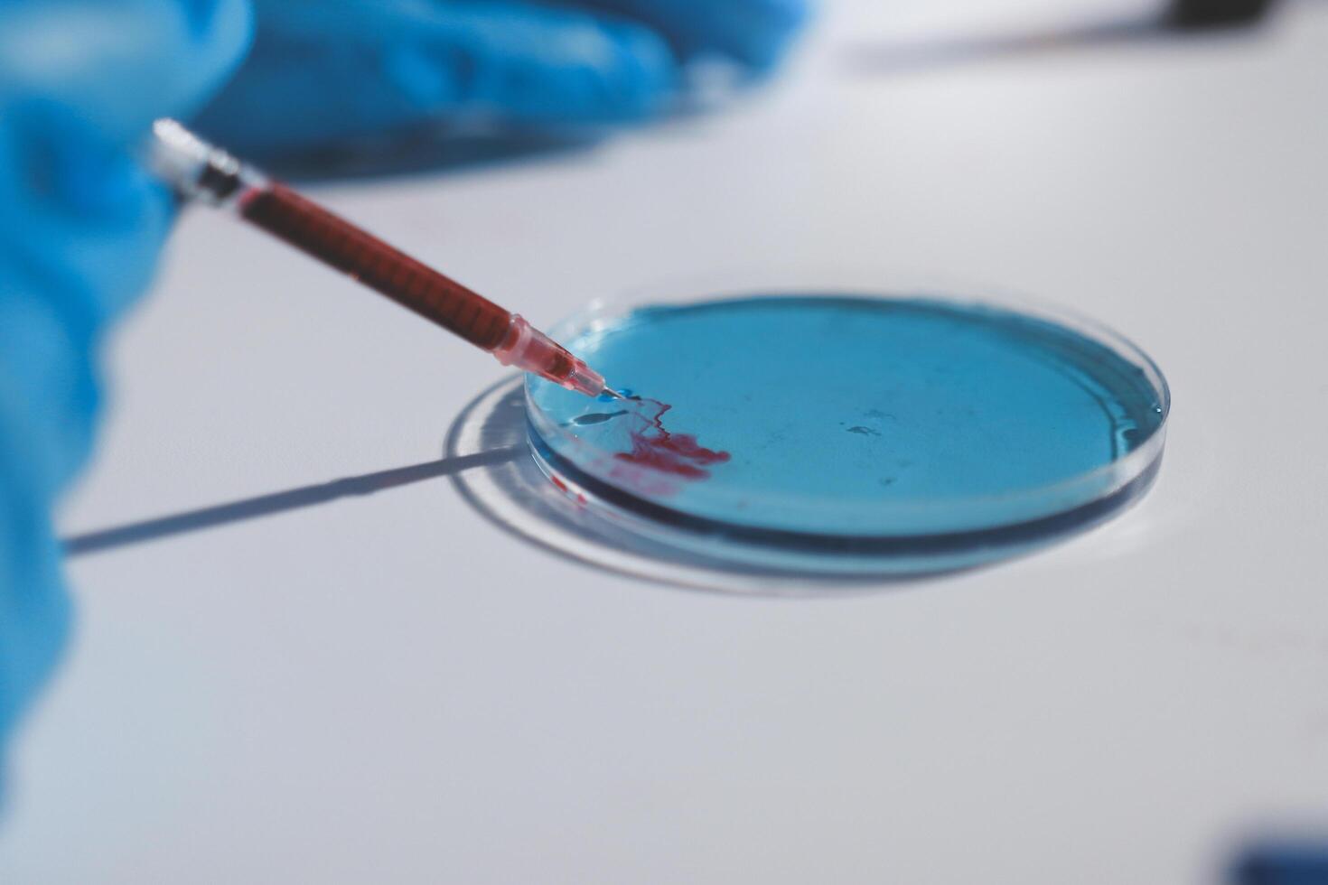 A person in blue gloves is holding a red stick photo