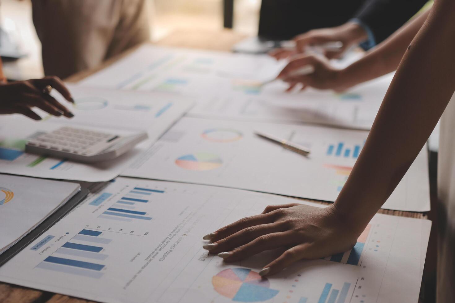Business people working on papers with graphs and papers photo