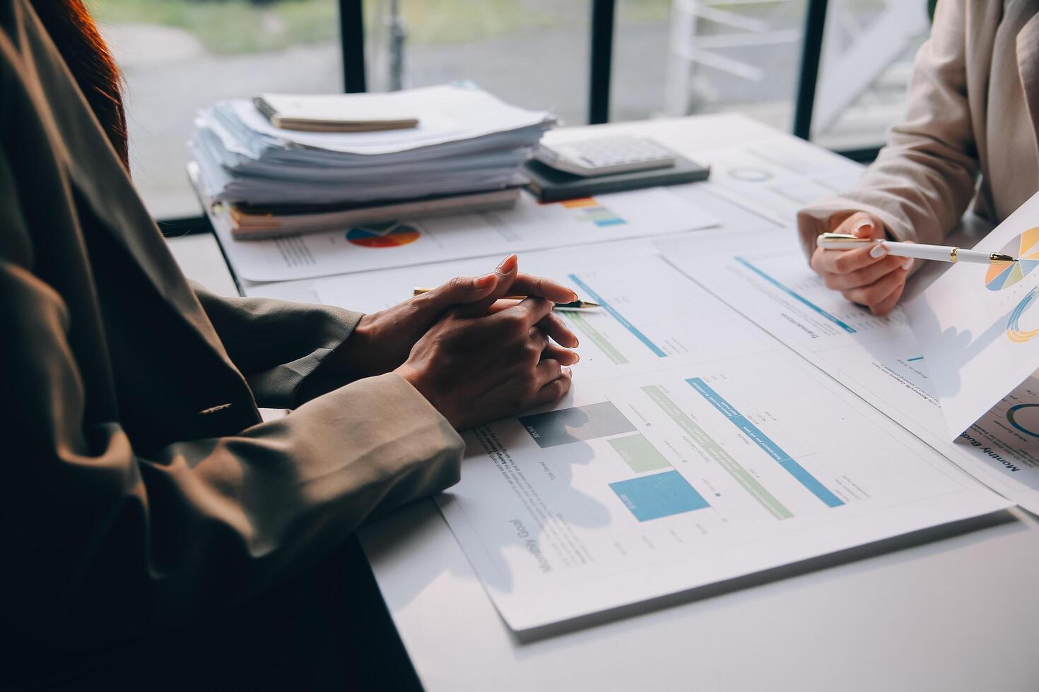 Two people at a table with papers and graphs photo