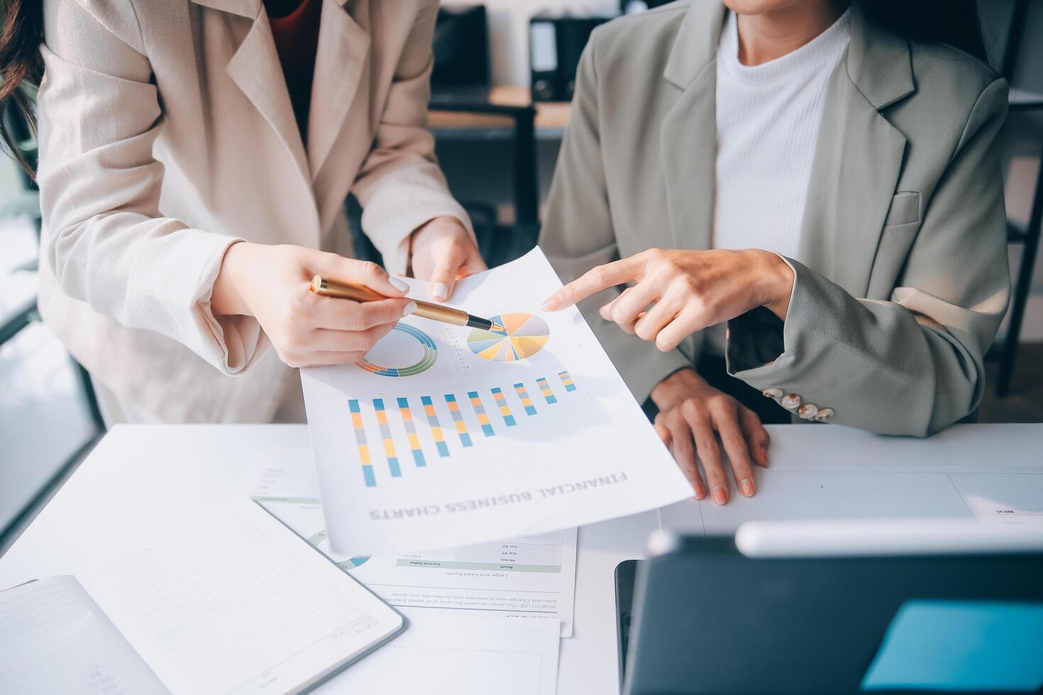 Two business people looking at graphs on a paper photo