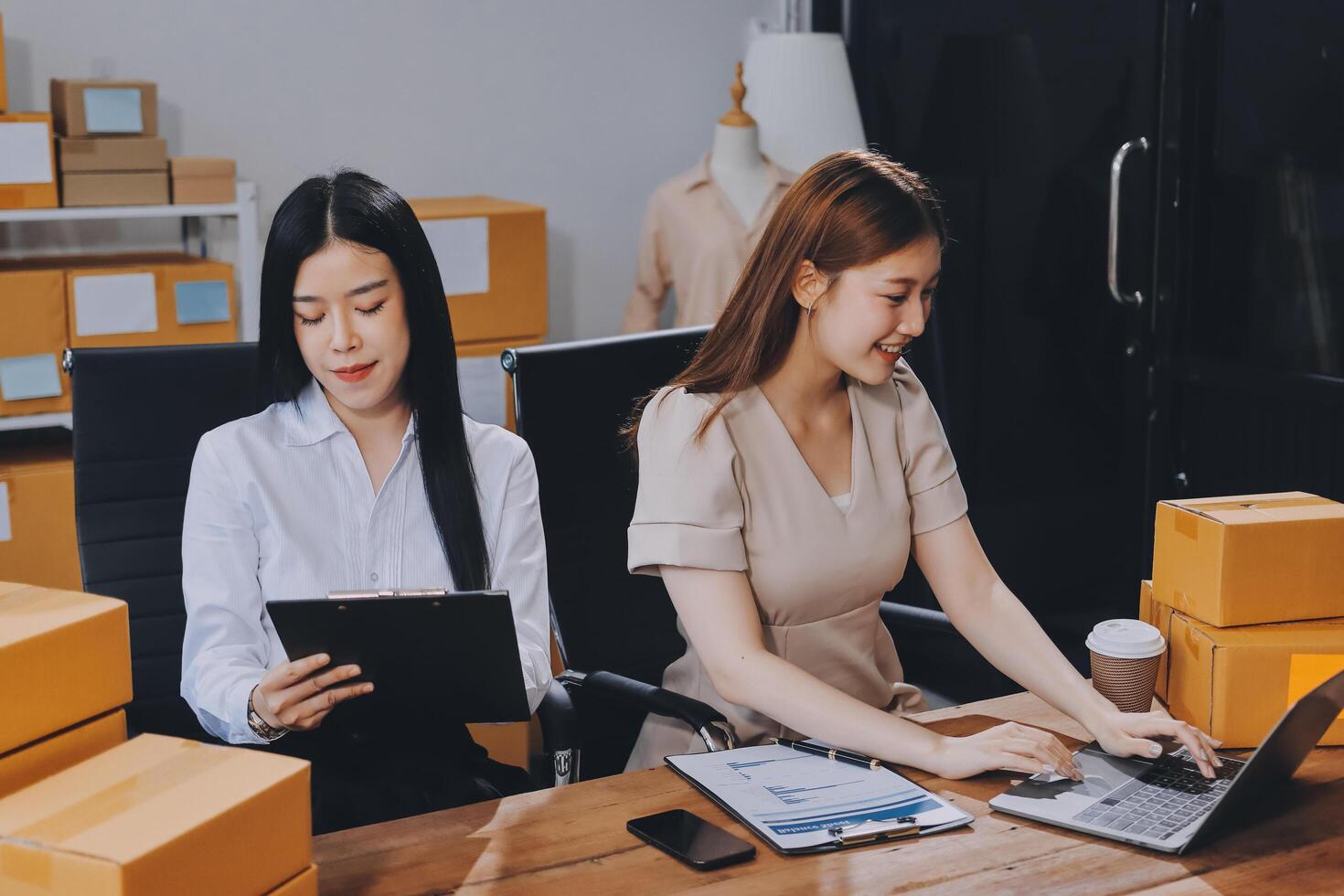 Two women working on laptops in an office photo