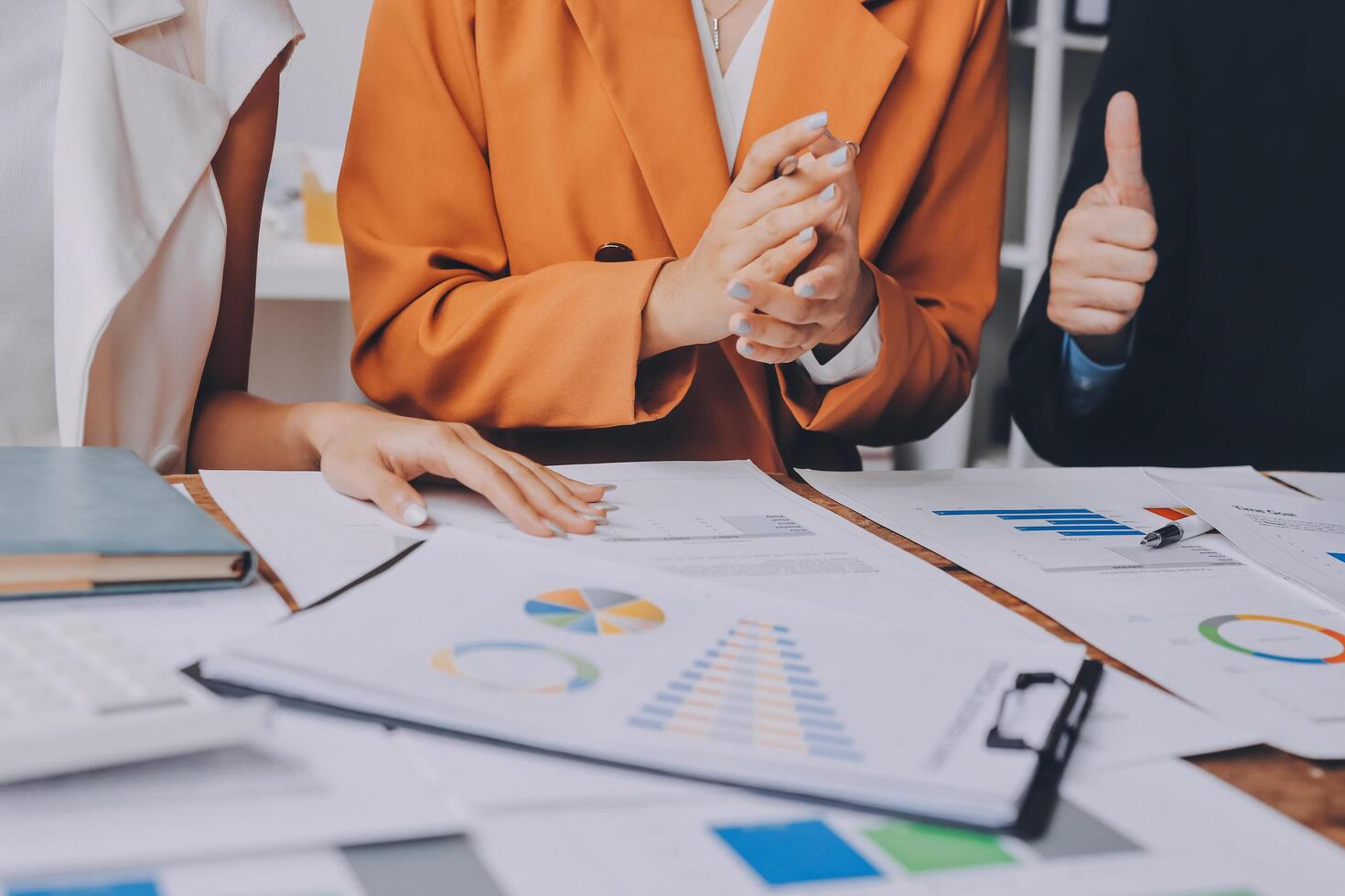Business people working on a project with graphs and papers photo