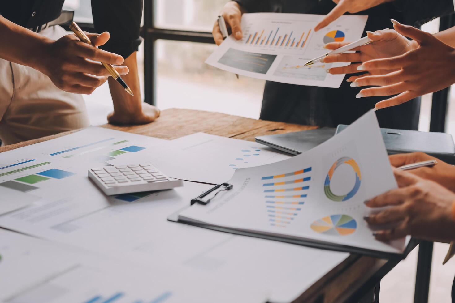 Business people working on a table with papers and graphs photo