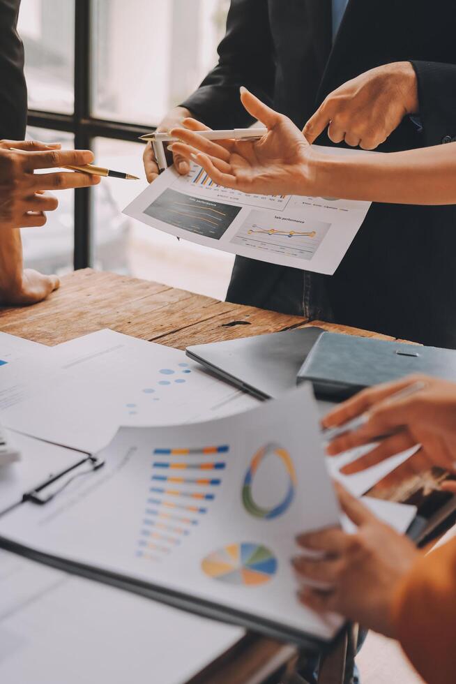 Business people at a table with papers and graphs photo