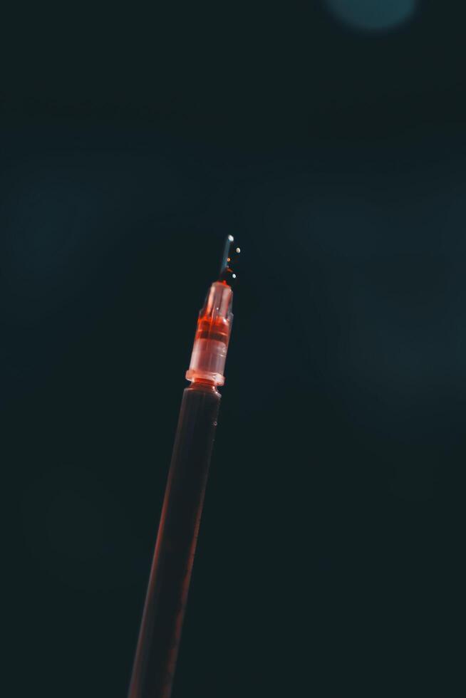 A red pen with a black tip on a dark background photo