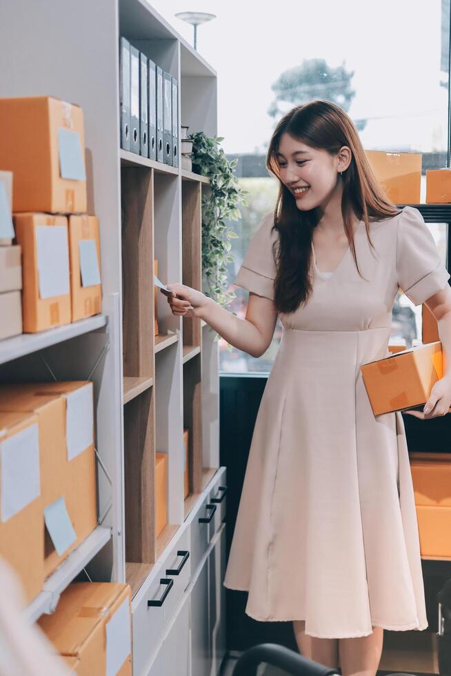 A woman in a dress is holding a box photo