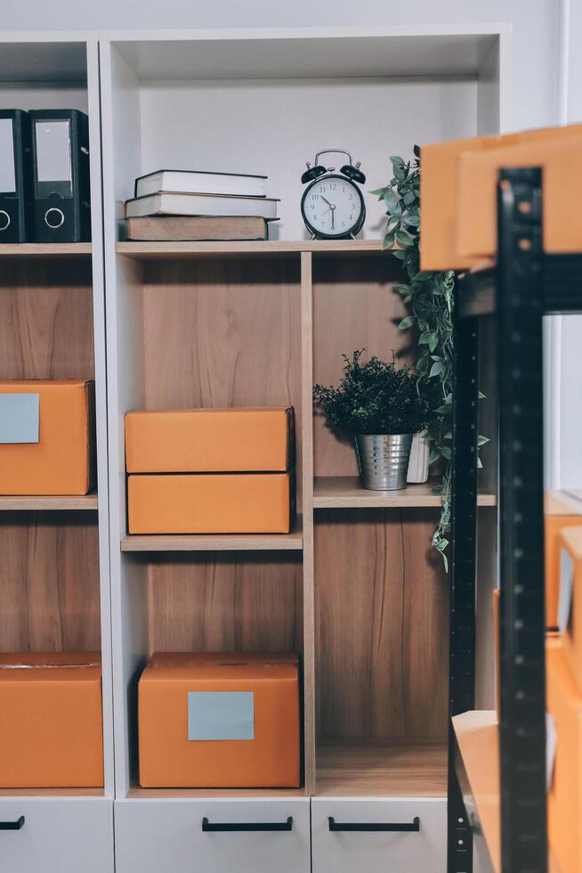 A shelf with orange boxes and a clock photo