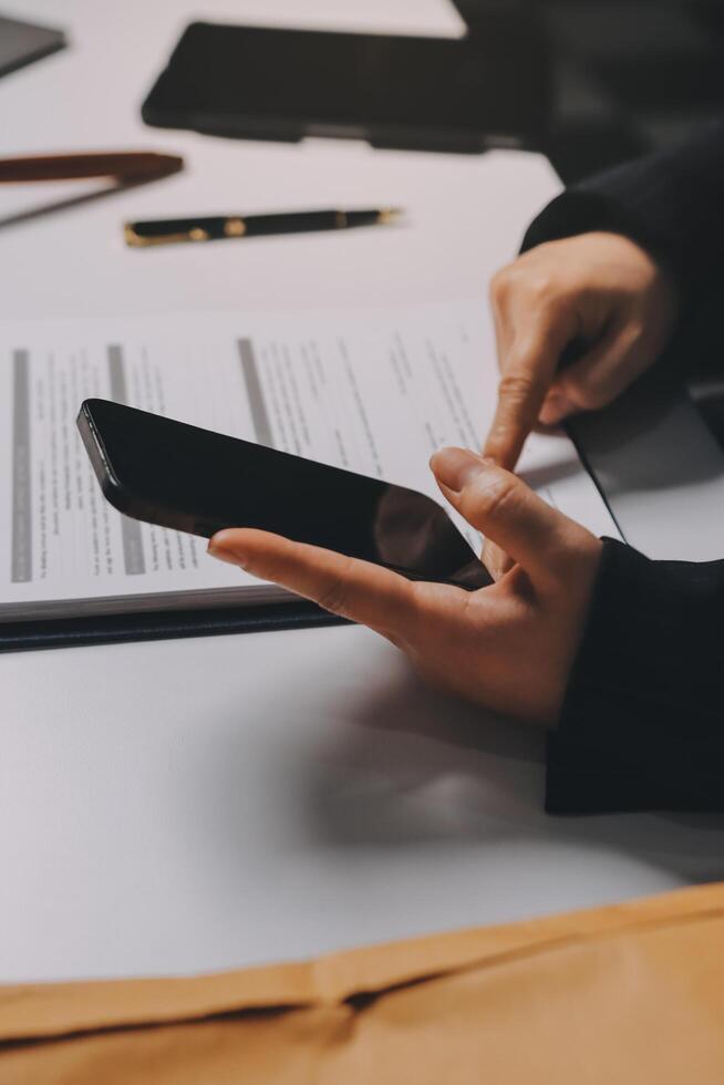 Businesswoman using smartphone to check documents photo