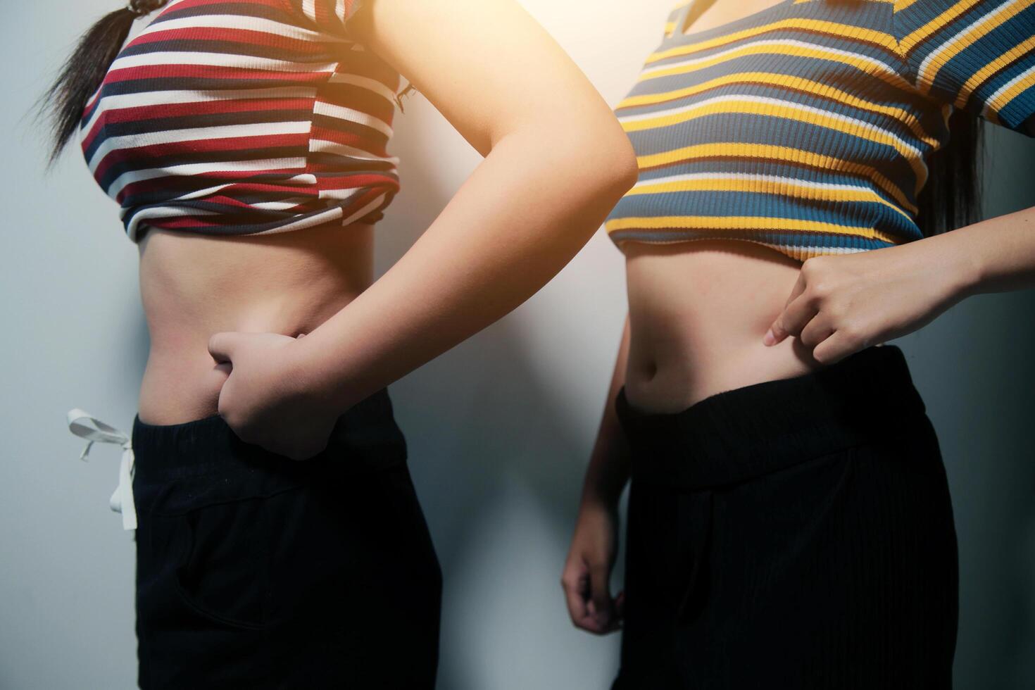 Two women standing next to each other with their hands on their hips photo