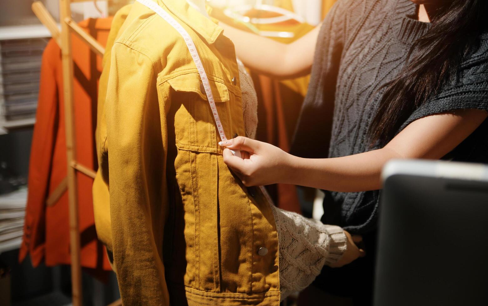 A woman is holding a jacket in front of a computer photo
