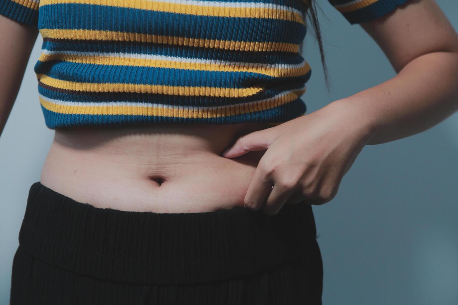 A woman with a belly showing off her stomach photo