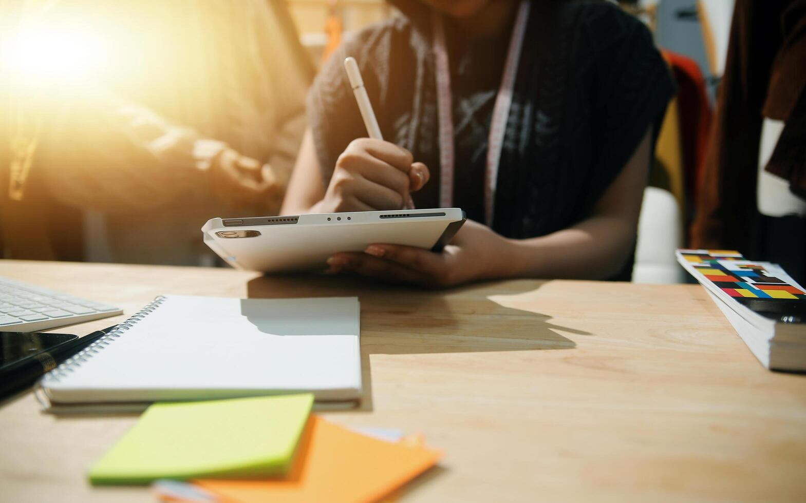 A woman is writing on a notepad while sitting at a desk photo