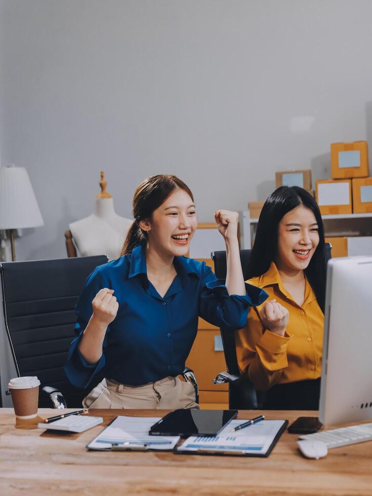 Two women in an office with their arms up photo