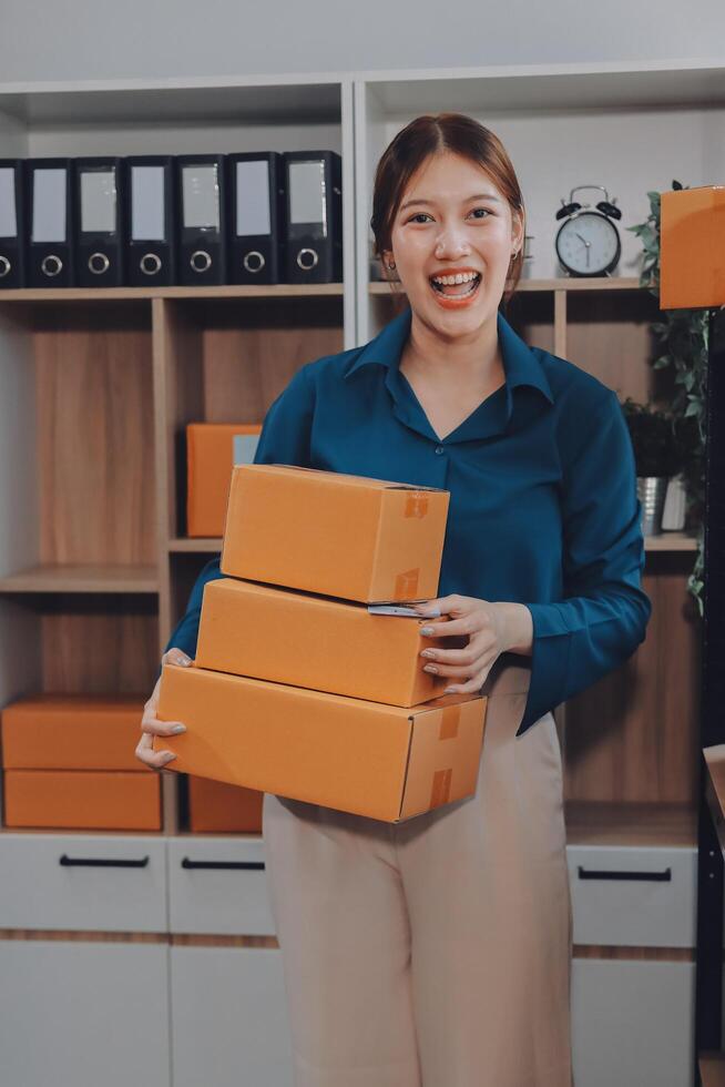 A woman holding three boxes in her office photo