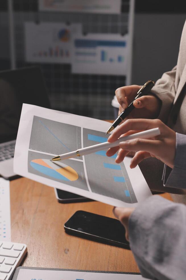 Business people working on a document with graphs and charts photo