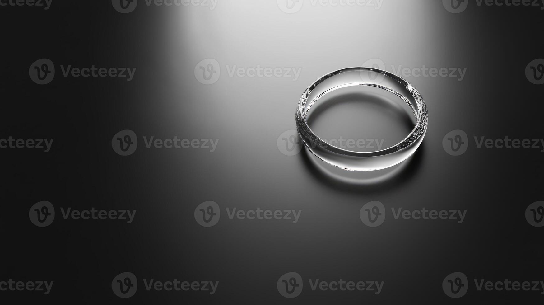 A clear ring is on a black background. The ring is not visible in the foreground photo