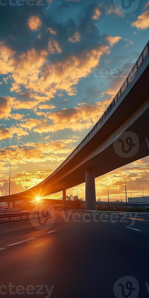 A breathtaking view of a sunset over an urban highway, showcasing dramatic clouds and vibrant colors in the sky. photo