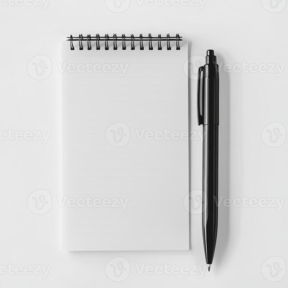 A top view of a black pen and a spiral notepad on a white surface, ideal for themes of writing, creativity, and organization. photo